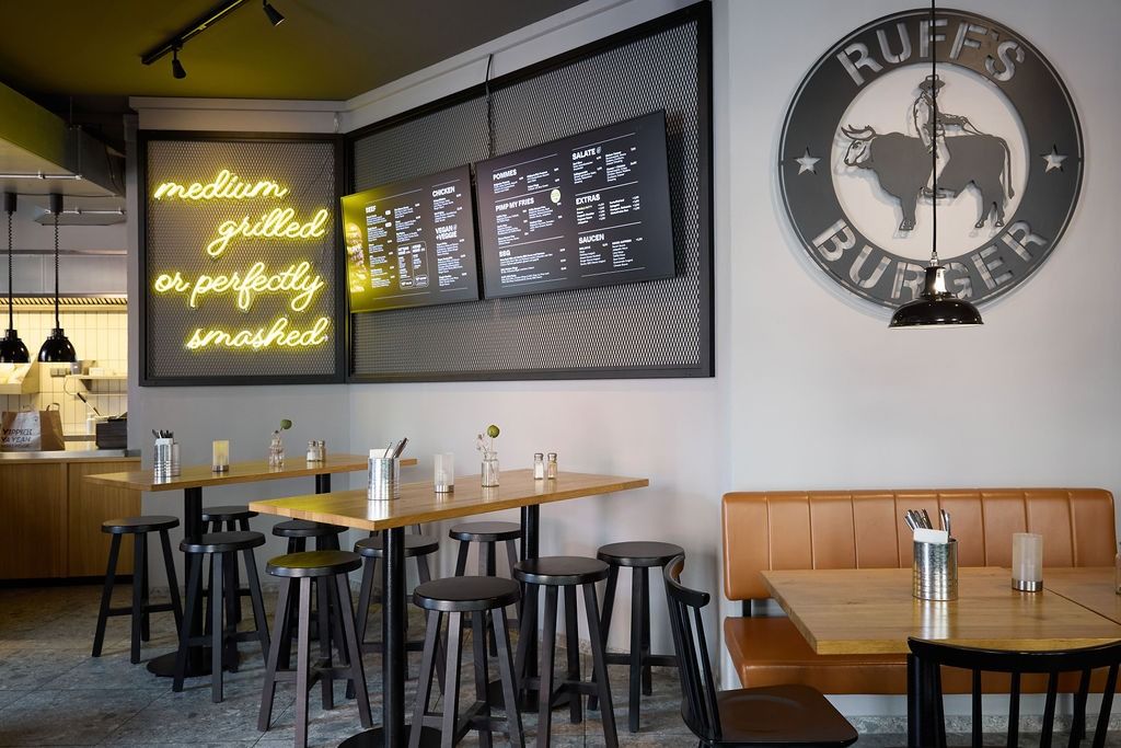 Innenbereich eines Ruff's Burger Restaurant mit Tischen und Barhockern