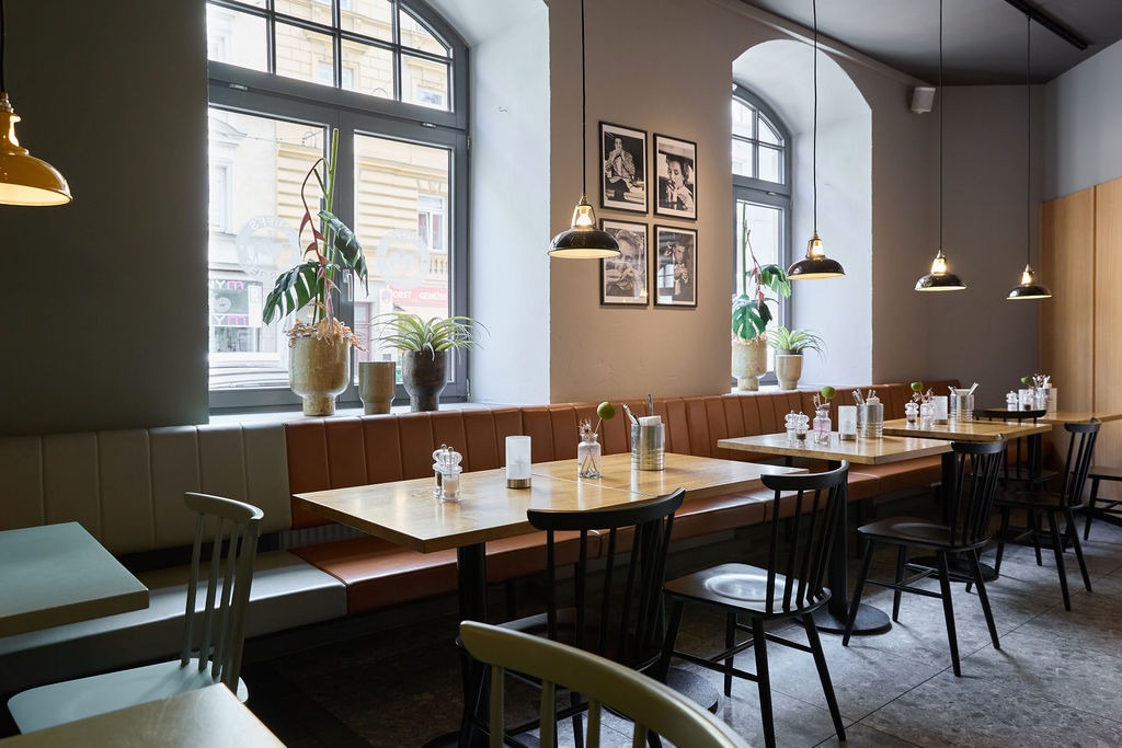 Sitzgruppe in einem Ruff's Burger Restaurant mit Sitzbank, Tischen und Stühlen.